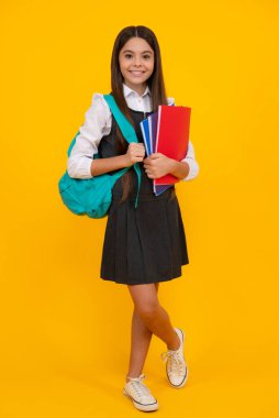 Okula dönelim. Genç liseli kızlar kitaplarını ve defterlerini öğrenmeye hazırlar. Okul çantalı çocuklar izole sarı stüdyo geçmişine sahipler.