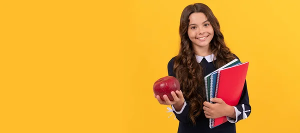 teen girl hold apple after study. healthy childhood. happy kid going to do homework. Banner of schoolgirl student. School child pupil portrait with copy space