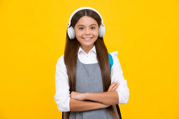 헤드폰을 노란색 스튜디오 배경에 여학생입니다 학교와 학교로 돌아가 소녀의 긍정적 — 스톡 사진