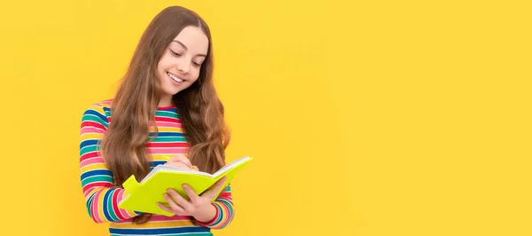 幸せな女の子の子供はコピー本の黄色の背景で書く 女子学生の肖像画 スタジオバナーヘッダー 学校の子供の顔 コピースペース — ストック写真