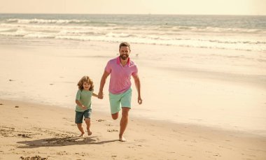 Baba, baba, baba, oğul plajda, tatilde koşuyor..