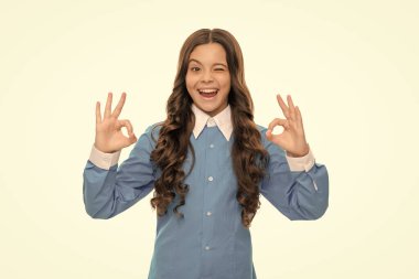 Kıvırcık saçlı göz kırpan çocuk. Güzellik ve moda. Kadın manken. Genç bir kızın güzel görünüşü. Beyaz arka planda izole edilmiş mutlu çocuk portresi. Olumlu duygularını ifade et. yüz derisi.