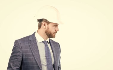 Ciddi ve güvenilir bir mühendis. İnşaat mühendisi beyazı izole etti. Şapkalı ve takım elbiseli bir iş adamı. Profesyonel bir adamın profil portresi. Mühendislik servisini çağırın, kopyalayın..