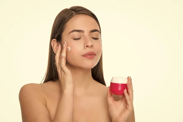 young woman applying cream for face skin with hand isolated on white background, personal care.