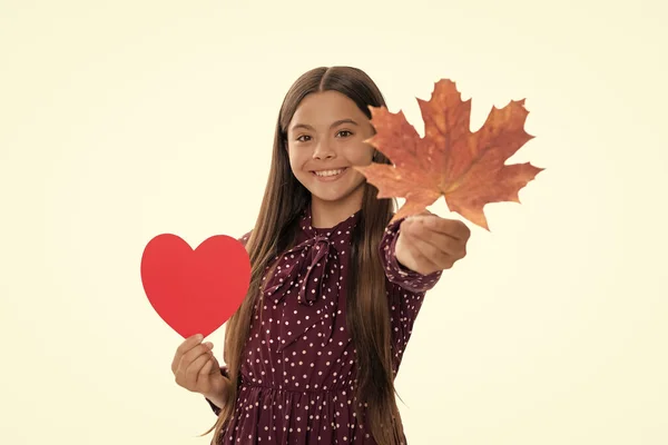 happy teen girl in fall season giving maple leaf and love heart isolated on white, selective focus, love.