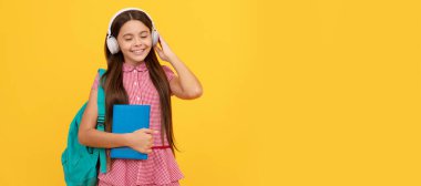 Okul çantalı neşeli çocuk. Müzik. Genç kız sırt çantası taşıyor. Okula dönüyorum. Liseli kız öğrenci pankartı. Kopya alanı olan öğrenci portresi