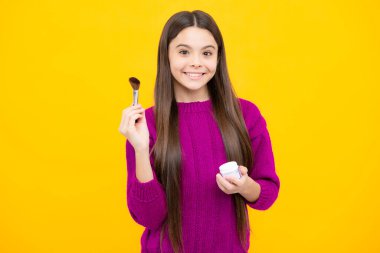 Genç kız ressamın güzel portresi makyaj fırçasıyla pudra sürüyor. Makyaj ürünleri. Gençler için güzellik ve kozmetik.