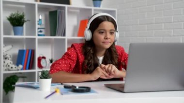 Kulaklıklı çocuk bilgisayarda video izlemeyi bekliyor. Yüzü ve teknolojisi inanılmaz..