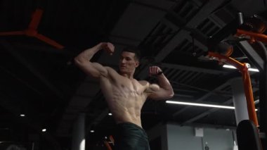 Spor salonunda kaslı vücutlu vücut geliştiren adam. Vücut geliştirmedeki sporcu pozu. Spor salonunda vücut geliştirme sporcusu. vücut geliştirme.