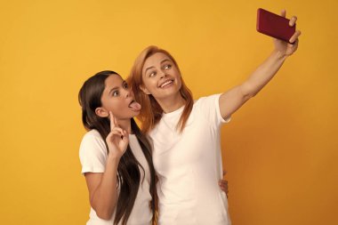 Mutlu havalı anne ve çocuk telefonda selfie çekiyor, içerik yapıcı..