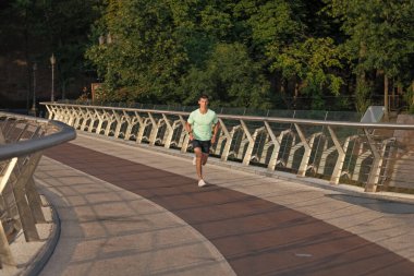 Spor giysileriyle koşan atletik bir koşucu..