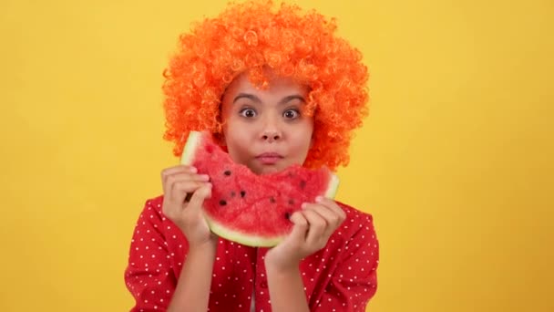 Έκπληκτος Χαρούμενος Παιδί Πορτοκαλί Περούκα Τρώει Φέτα Του Καρπουζιού Φρούτων — Αρχείο Βίντεο