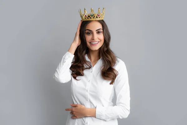 Woman queen. Portrait of ambitious girl with crown, feeling princess, confidence. Studio shot isolated on gray background