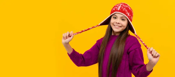 耳フラップの帽子の幸せな子供 子供は黄色い背景に暖かいニットの服を着てる クリスマスの子供の女の子のバナー スタジオの子供の冬の肖像画とともにコピースペース — ストック写真