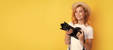 Hasır şapkalı, fotoğraf çeken mutlu kızıl saçlı kadın fotoğrafçı, yaz çekimi. İzole edilmiş yüz portresi, taklit alanı olan pankart