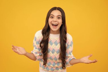 Heyecanlı bir yüz. Şaşırtıcı bir ifade, neşeli ve mutlu. Kaldırılmış ellerle neşeli bir genç kızın portresi. Sarıda izole edilmiş beyaz bir genç çığlık atıyor. Mutlu çocuk sevinç ve heyecanla bağırıyor.