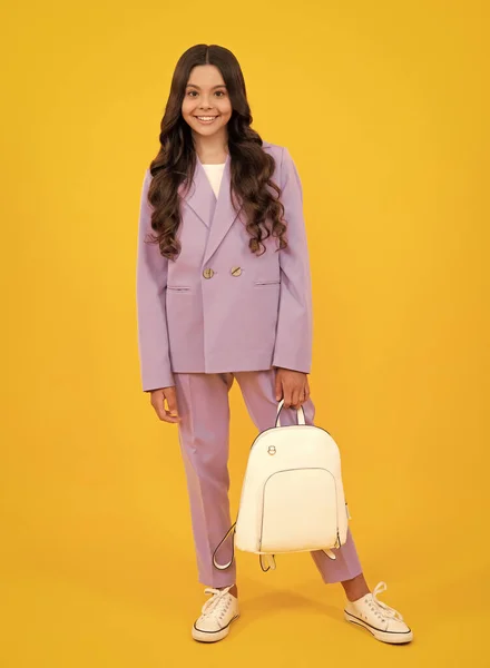 穿着校服 背着书包的女学生 十几岁的孩子把背包放在黄色孤立的背景上 少女快乐的脸庞 积极的微笑的情绪 — 图库照片