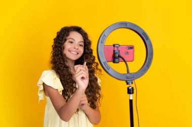 Çocuk video kaydedicisi telefonda video blogu yapıyor. Web günlüğü ve vlog. Genç kız blogger etkileyicisi sosyal medya için video kaydediyor. Mutlu ergen, pozitif ve gülümseyen genç kız duyguları