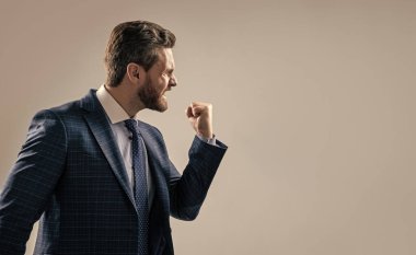 Saldırgan takım elbiseli işadamı, gri arka plan fotokopi alanını tehdit eden birine el kol hareketi yaptı..