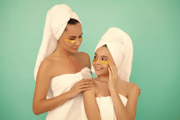 family spa of mother and daughter with facial patch.