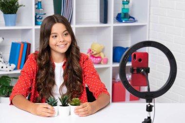 Çocuk video kaydedicisi telefonda video blogu yapıyor. Web günlüğü ve vlog. Genç kız blogger etkileyicisi sosyal medya için video kaydediyor. Mutlu kız yüzü, pozitif ve gülümseyen duygular