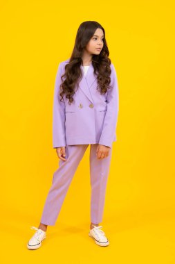 Stüdyoda sarı arka planda izole edilmiş genç kız kıyafetleri. Çocuk yaşam tarzı konsepti