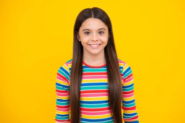 Stüdyonun arka planında izole edilmiş genç bir kızın portresi. Çocukluk yaşam tarzı konsepti. Kopyalama alanı oluşturun. Mutlu yüz, pozitif ve gülümseyen genç kız duyguları