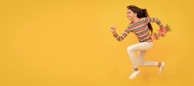 Koş ve atla. Mutlu enerjik genç kaykaycı kız kaykayla, pennyboard 'la atlıyor. Gündelik ergen çocuk posteri. Başlık, kopyalama alanı