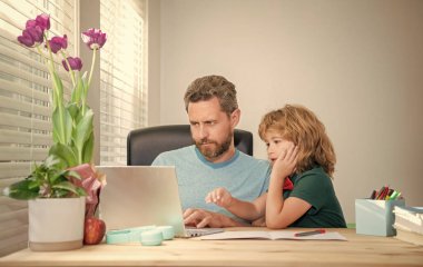 Bilgisayarda online eğitim. Evde eğitim ve para kazanmak. Okula dönüyorum. Konsantrasyon. Baba ve oğul evde bilgisayar kullanıyor. Aile blogu. Çocuk özel öğretmeniyle ödev yapıyor. webinar video dersi.