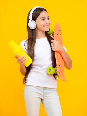 Stüdyoda kaykay yapan genç bir kız izole edilmiş bir geçmişi var. Bahar liseli kız modası, şehirli ergen tarzı. Mutlu ergen portresi. Gülümseyen kız