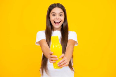 Plastik şişeden su içen genç bir kız çocuğu izole bir arka planda, kopyalama alanı. Çocuk bakım vücut sıvısı. Aktif eğlence ve su dengesi. Heyecanlı genç, mutlu ve şaşkın.