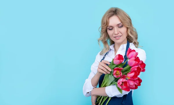 Mavi Arka Planda Bahar Lale Çiçekleri Olan Önlüklü Genç Bir — Stok fotoğraf