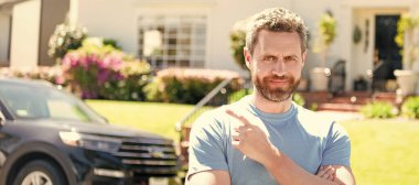 Torbacı adam arabayı ve yeni evi işaret ediyor. İnsan yüzü portresi, kopyalama alanı olan pankart