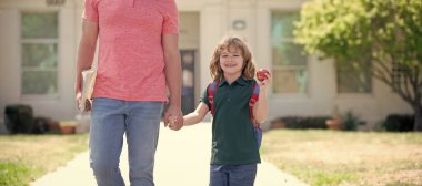Çocuğun okula geri dönmesi, eğitim. Okuldaki ilk günüm. Baba ve oğul okuldan dönüyorlar. Mutlu aile değeri