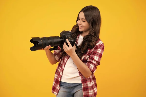 带着大镜头的专业摄影相机的少女的积极和微笑的情绪 黄色背景的儿童摄影师 照片学校 — 图库照片