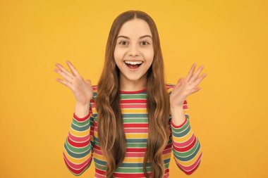 Heyecanlı çocuk suratı. Şaşırtıcı bir ifade, neşeli ve mutlu. Sarı arka planda ağzı açık hayret bir çocuk, sürpriz.