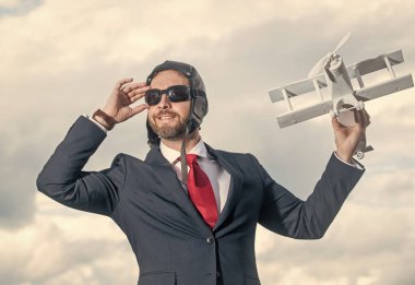 Pozitif takım elbiseli iş adamı ve pilot şapkalı uçak oyuncağı.