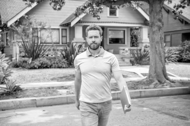 Sahiplik. Dışarıda dizüstü bilgisayarı olan olgun bir yerleşim yeri temsilcisi. Emlakçı mülk satıyor. Banliyödeki emlakçı. Adam yatırım amacıyla ev satın alıyor. emlak sigortası hizmetleri.