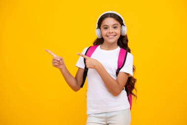İzole edilmiş stüdyo geçmişi olan kulaklıklı bir kız öğrenci. Okul ve müzik konsepti