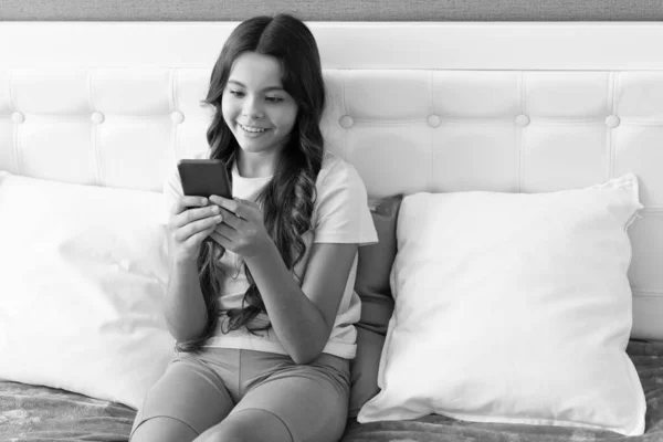 Happy Kid Texting Mobile Phone While Sitting Bed Text — стоковое фото