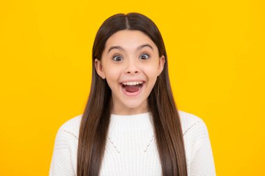 Heyecanlı bir yüz. Şaşırtıcı bir ifade, neşeli ve mutlu. Kafkasyalı genç kızın yakın portresi. Sarı izole edilmiş stüdyo arka planında sevimli bir gencin fotoğrafı.