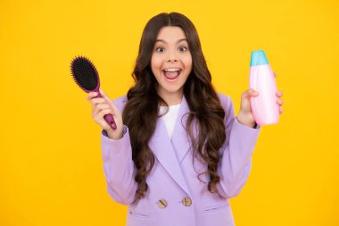 Şampuan kremi kullanan bir çocuk. Günlük kozmetik bakım. Gençlerin elinde saç ve cilt bakımı şişesi var. Güzellik sağlığı ve kozmetik ürünleri. Heyecanlı genç kız