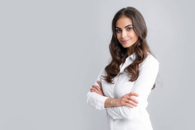 Gayri resmi giyinmiş, tatmin olmuş güzel bir kadın. Gri arka planda izole edilmiş güzel bir kadının stüdyo fotoğrafı.