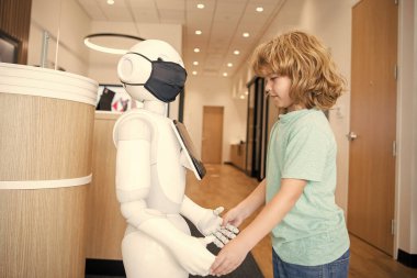 Küçük çocuk robotla yenilikçi bir teknoloji olarak etkileşim içinde. İletişim..