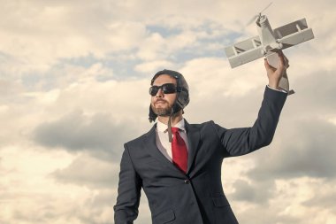 Takım elbiseli iş adamı ve pilot şapkalı uçak oyuncağı. başarı.