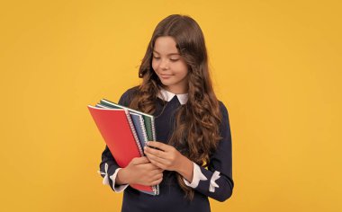 çocukluk. Yüzünde gülümseme olan çocuk ödevini yapmaya gidiyor. Öğrenci defterleri tutuyor. Lisede eğitim. Not defterli kız öğrenci. Okula dönüyorum. Genç kız çalışmaya hazır..