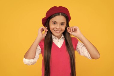 Sarı arka planda Fransız bereli mutlu liseli kız, güzellik.