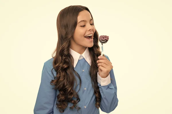 happy child long curly hair eat chocolate candy on stick isolated on white, yummy.