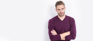 Kendinden emin ve rahat hissediyorum. Kendine güvenen bir adam kollarını çapraz olarak beyazın üzerinde tutar. Sıradan bir tarz. İnsan yüzü portresi, kopyalama alanı olan pankart