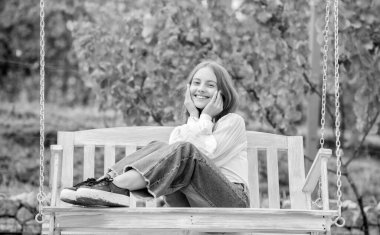 Park yerinde rahatla. Yaz etkinliği. pozitif duygular. Salıncaktaki güzel çocuk. Çocuk dışarıda sallanıyor. Genç kız oyun alanında eğleniyor. çocukluk mutluluğu.